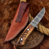 Custom Damascus skinning knife with sheep horn handle, 7.75-inch blade, and leather sheath