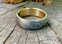 Intricate patterns on a Damascus steel ring with brass inlay