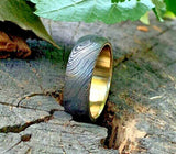 Man wearing a custom Damascus steel anniversary ring with brass inlay

