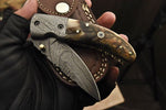 Custom Damascus steel folding pocket knife with a sheep horn handle and Damascus bolsters.
