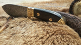 Detail view of the full tang design of the Damascus steel blade for enhanced strength and durability.