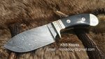 Personalized deer skinning knife showcasing a 4-inch clip point Damascus steel blade and buffalo horn handle.