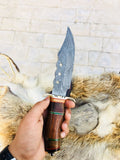 "Close-up of walnut wood handle and brass guard on the hunting knife."
